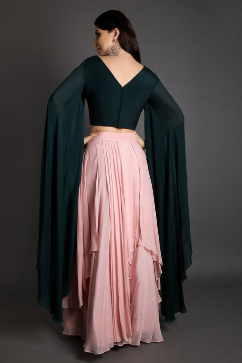 Baby pink asymmetric skirt with long flared and slit sleeves crop top.