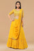 Mustard yellow skirt with gathers below and attached drape from the waist with crop top.