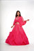 Hot pink poncho style crop top with tie and rushed and ruffled flared skirt.