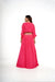 Hot pink poncho style crop top with tie and rushed and ruffled flared skirt.