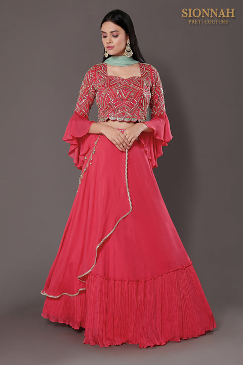 Coral pink layered skirt with accessory and crop top and skirt and dupatta.