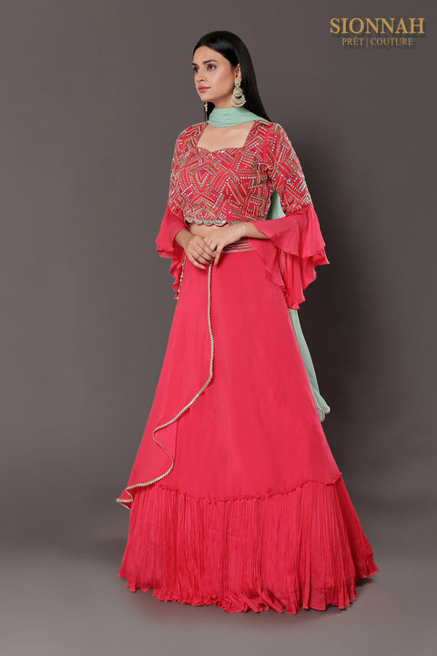 Coral pink layered skirt with accessory and crop top and skirt and dupatta.